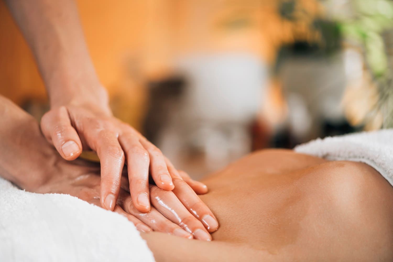 Manos aplicando aceite en un masaje bioenergético en Hathor, Bilbao